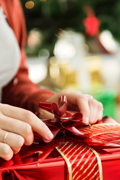 Mujer abriendo un regalo rojo