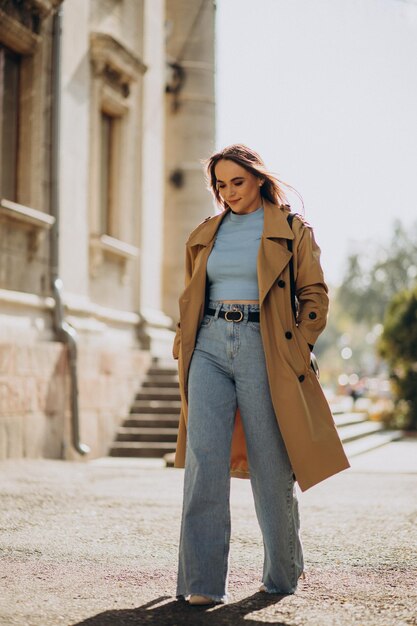 Mujer de abrigo beige caminando por la calle