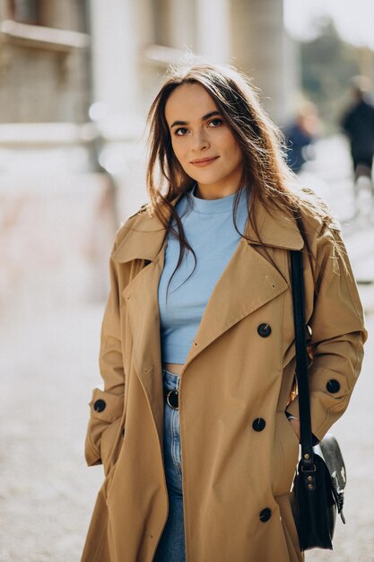 Mujer de abrigo beige caminando por la calle