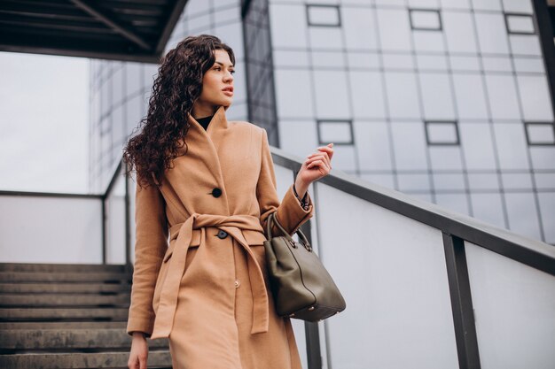 Mujer en abrigo beige caminando en la ciudad