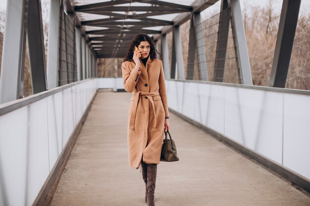 Mujer en abrigo beige caminando en la ciudad