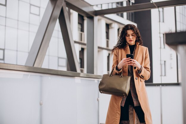 Mujer en abrigo beige caminando en la ciudad