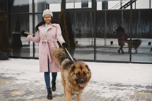 Mujer con un abrigo rosa con perro