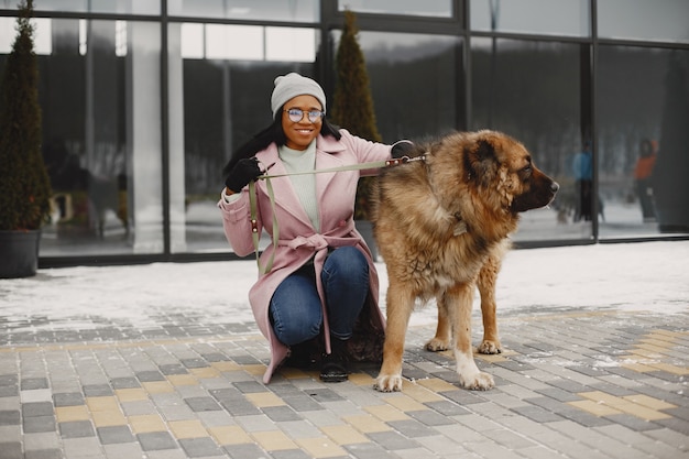 Mujer con un abrigo rosa con perro