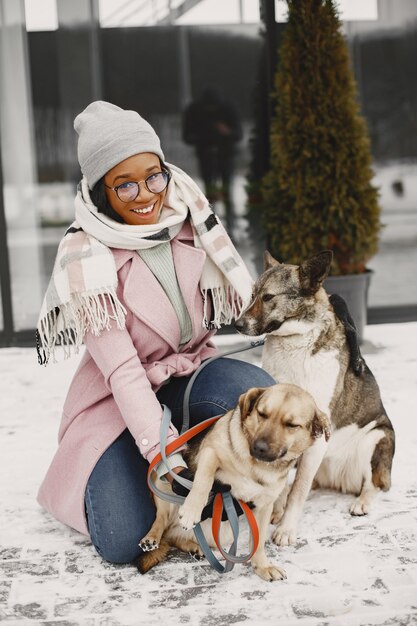 Mujer con un abrigo rosa, perros paseantes