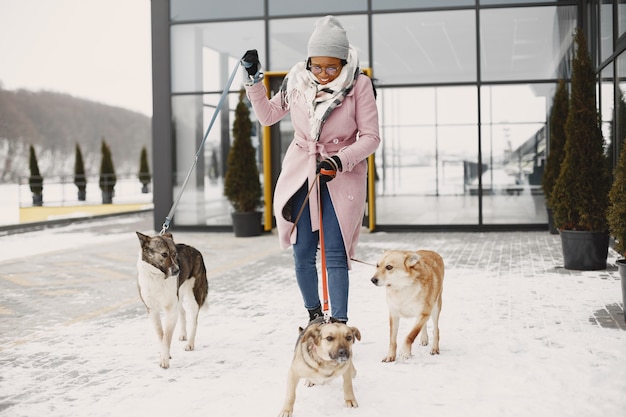 Mujer con un abrigo rosa, perros paseantes