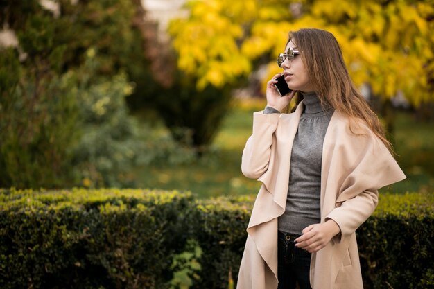 Mujer en abrigo con teléfono