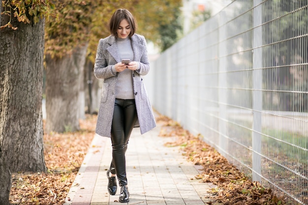 Foto gratuita mujer en abrigo con teléfono