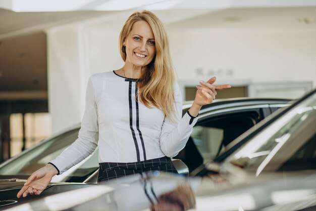 Mujer acaba de comprar su coche nuevo en un salón de autos