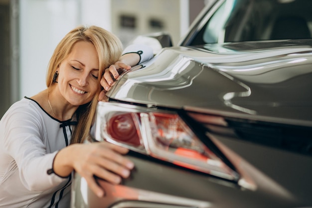 Mujer acaba de comprar su coche nuevo en un salón de autos