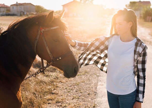 Mujer acariciando adorable caballo