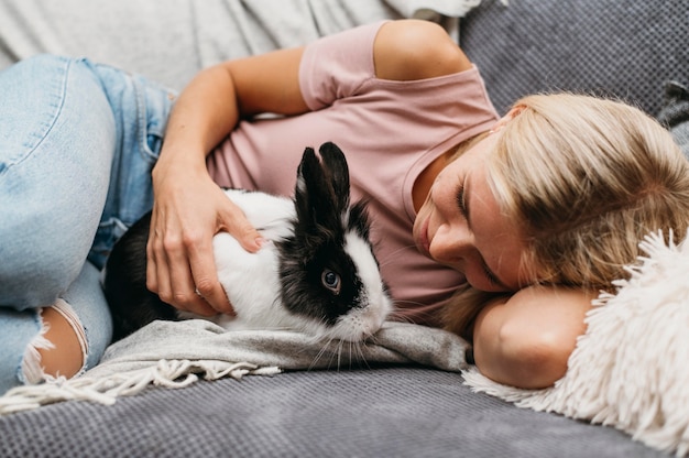 Foto gratuita mujer acariciando adorable conejo