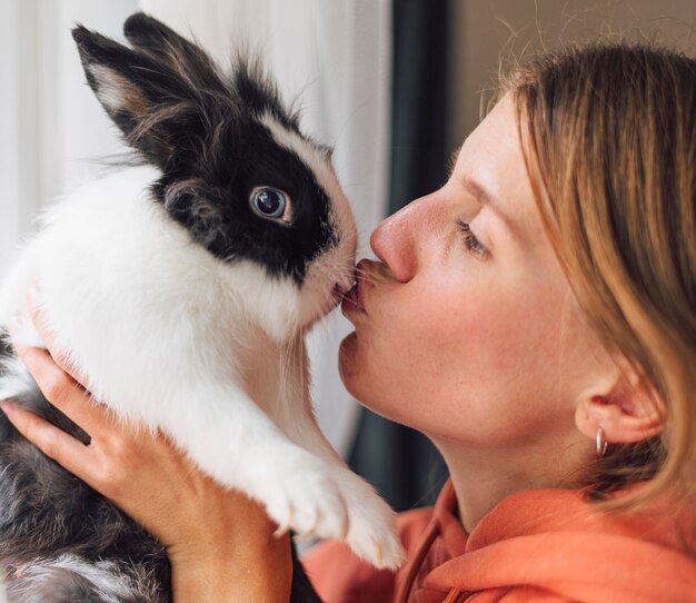 Mujer acariciando adorable conejo