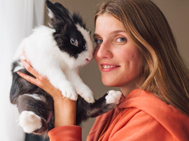 Mujer acariciando adorable conejo