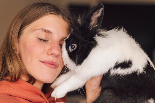 Mujer acariciando adorable conejo