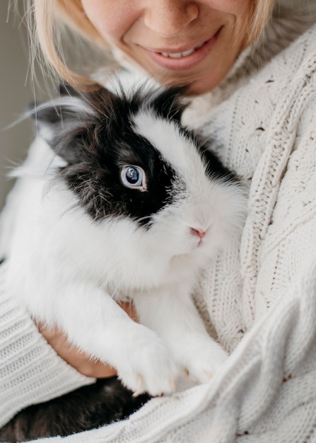 Mujer acariciando adorable conejo