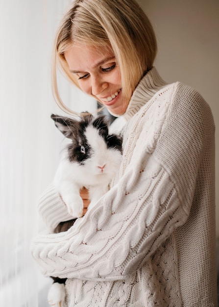 Mujer acariciando adorable conejo