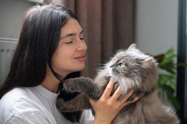 Mujer acariciando a su gato en casa durante la cuarentena