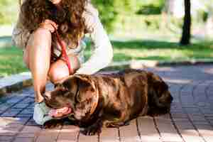 Foto gratuita mujer acariciando a su perro en el jardín