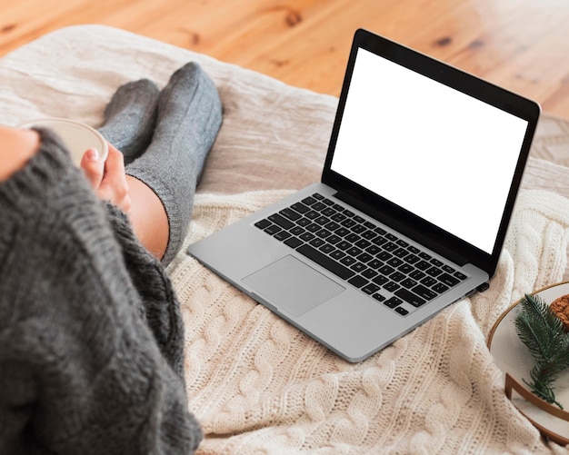 Mujer acogedora con laptop en la cama