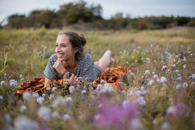 Mujer acostada en un campo de flores durante el día