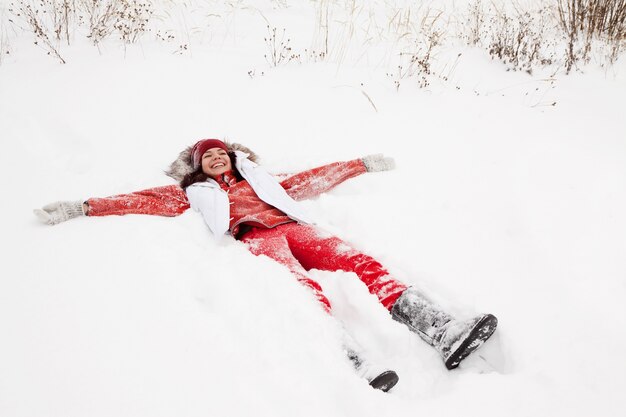 Foto gratuita mujer acostada en la nieve