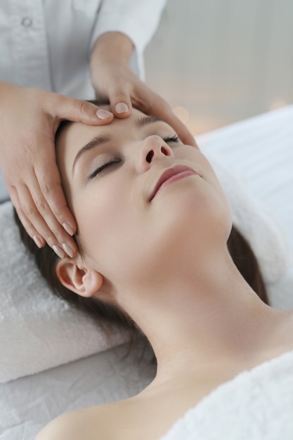 Foto gratuita mujer acostada recibiendo un masaje. terapia craneosacral