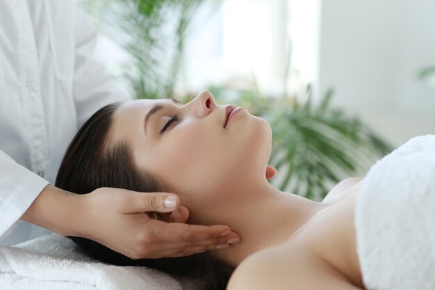 Mujer acostada recibiendo un masaje. Terapia craneosacral