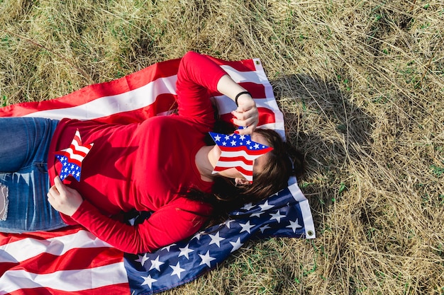 Mujer, acostado, en, tela, de, bandera estadounidense, en, campo