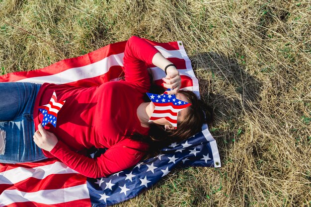 Mujer, acostado, en, tela, de, bandera estadounidense, en, campo