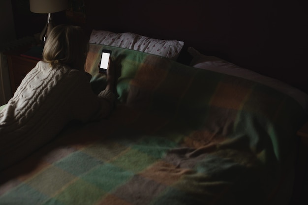 Mujer, acostado, y, utilizar, teléfono móvil, en cama