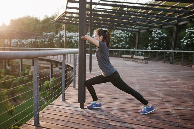 Mujer activa estirando al atardecer