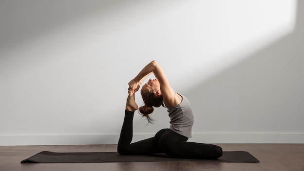 Mujer activa practicando yoga en casa