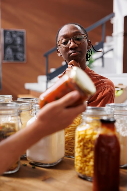 Foto gratuita una mujer admira un frasco de productos alimenticios rojos