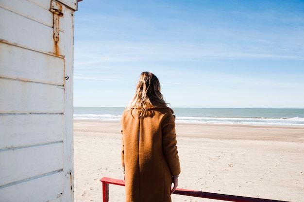 Foto gratuita mujer admirando la playa desde casa pontón