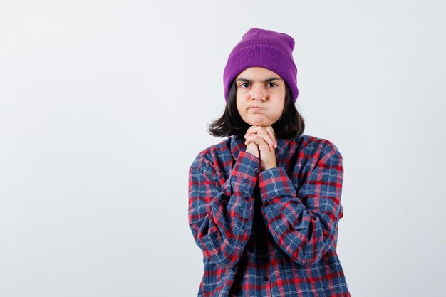 Foto gratuita mujer adolescente en camisa a cuadros y gorro gesticulando aislado