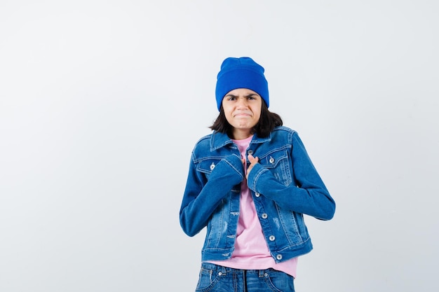 Foto gratuita mujer adolescente cogidos de la mano sobre el pecho y haciendo muecas en camiseta rosa