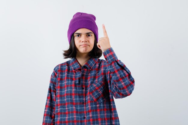 Mujer adolescente levantando el dedo índice en gesto de eureka mirando sensible