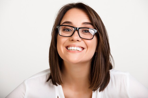 Mujer adulta alegre en gafas, sonriendo con dientes