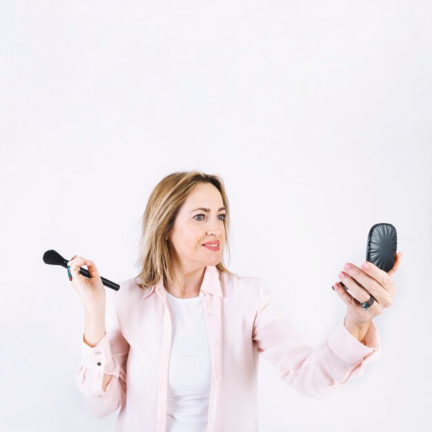 Mujer adulta aplicando maquillaje