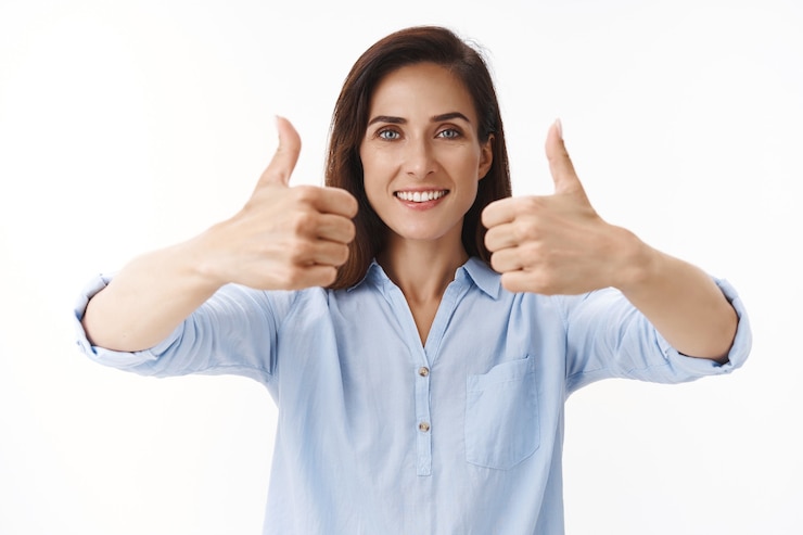 Foto gratuito mujer adulta atractiva y solidaria con tatuajes, empresaria da señal de aprobación con el pulgar hacia arriba, sonriendo entretenido encantado de escuchar un buen concepto, aceptar términos