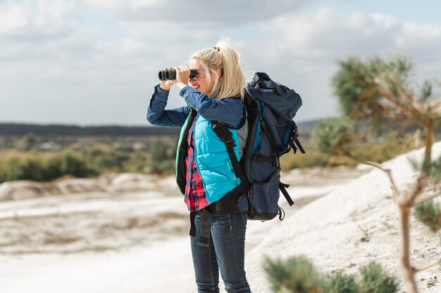 Mujer adulta con binoculares al aire libre