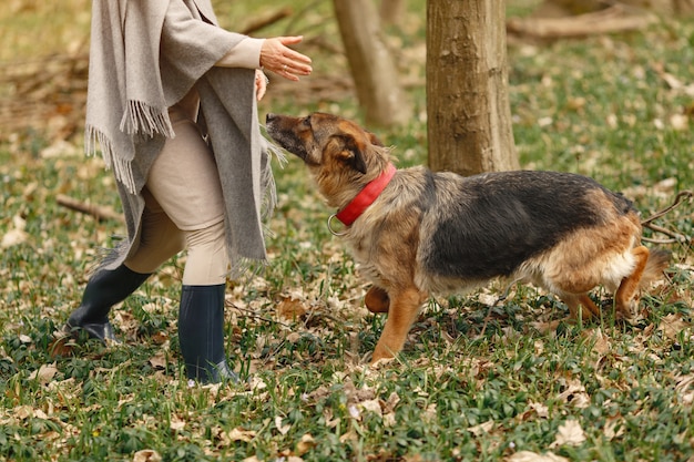 Mujer adulta en un bosque de primavera con perro