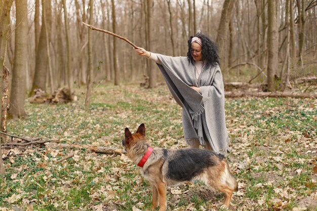 Mujer adulta en un bosque de primavera con perro