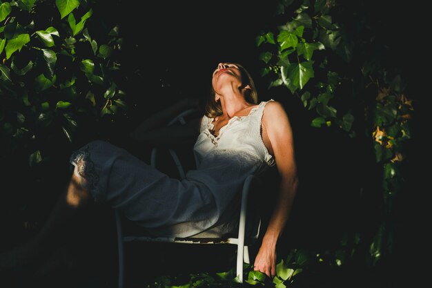 Mujer adulta durmiendo en el jardín