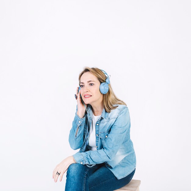 Mujer adulta escuchando música cuidadosamente