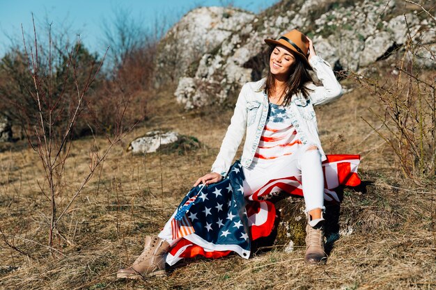 Mujer adulta feliz con bandera con sombrero