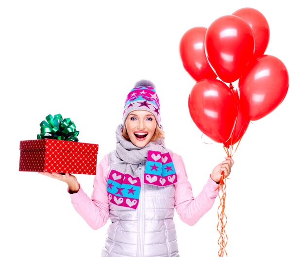 Mujer adulta feliz divertida con caja de regalo roja y globos aislados en blanco