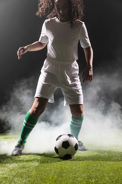 Mujer adulta en forma jugando al fútbol