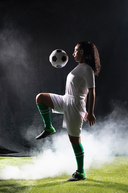 Mujer adulta en forma jugando con fútbol